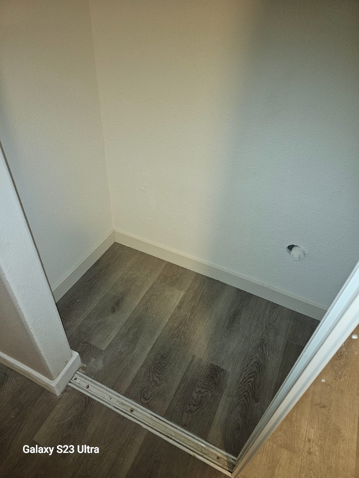 Spacious room with dark wood flooring and modern lighting