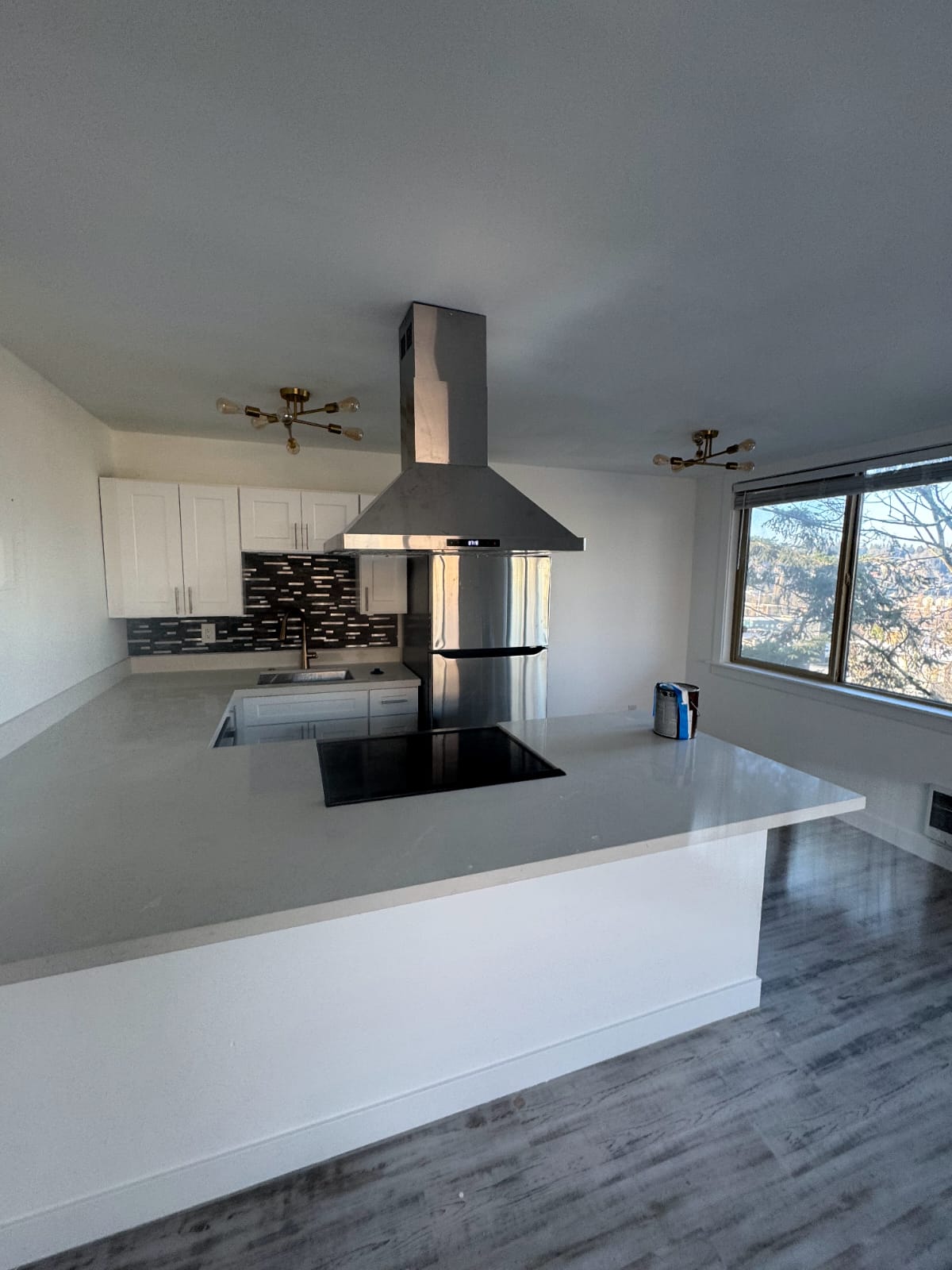 Bright kitchen space with white cabinets and modern lighting